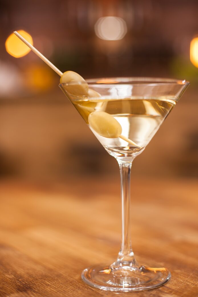 closeup-of-martini-glass-with-olives-on-wooden-table-in-resturant-fresh-drink-tasty-drink-alcoholic-drink-min