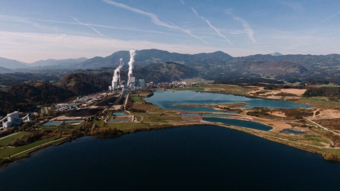 aerial-shot-of-landscape-surrounded-by-mountains-and-lakes-with-industrial-disaster-min