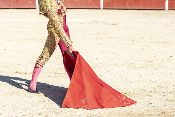 picture-of-bullfighter-or-matador-in-traditional-clothes-and-red-fabric-min